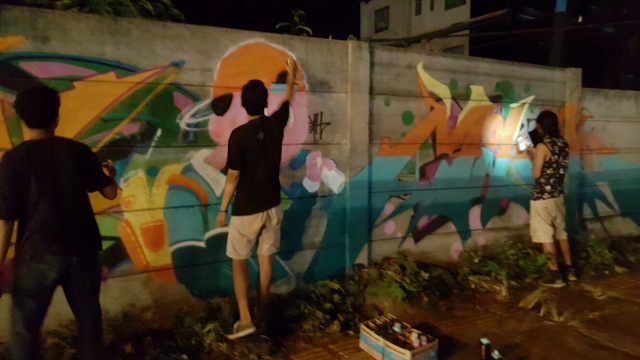 Grafitti writers tengah melukis sebuah tembok pagar di Kota Cilegon. (Foto : Gilang)