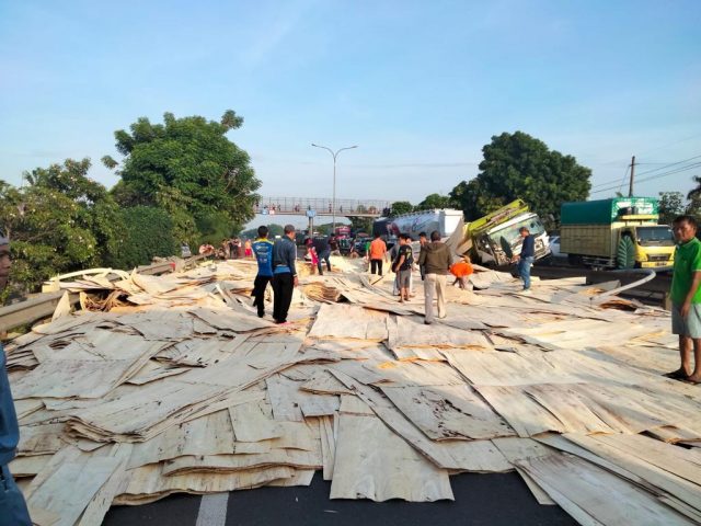 Meterial triplek memenuhi jalan Tol Tangerang-Merak KM 74B arah Jakarta pada Sabtu (14/1/2023).